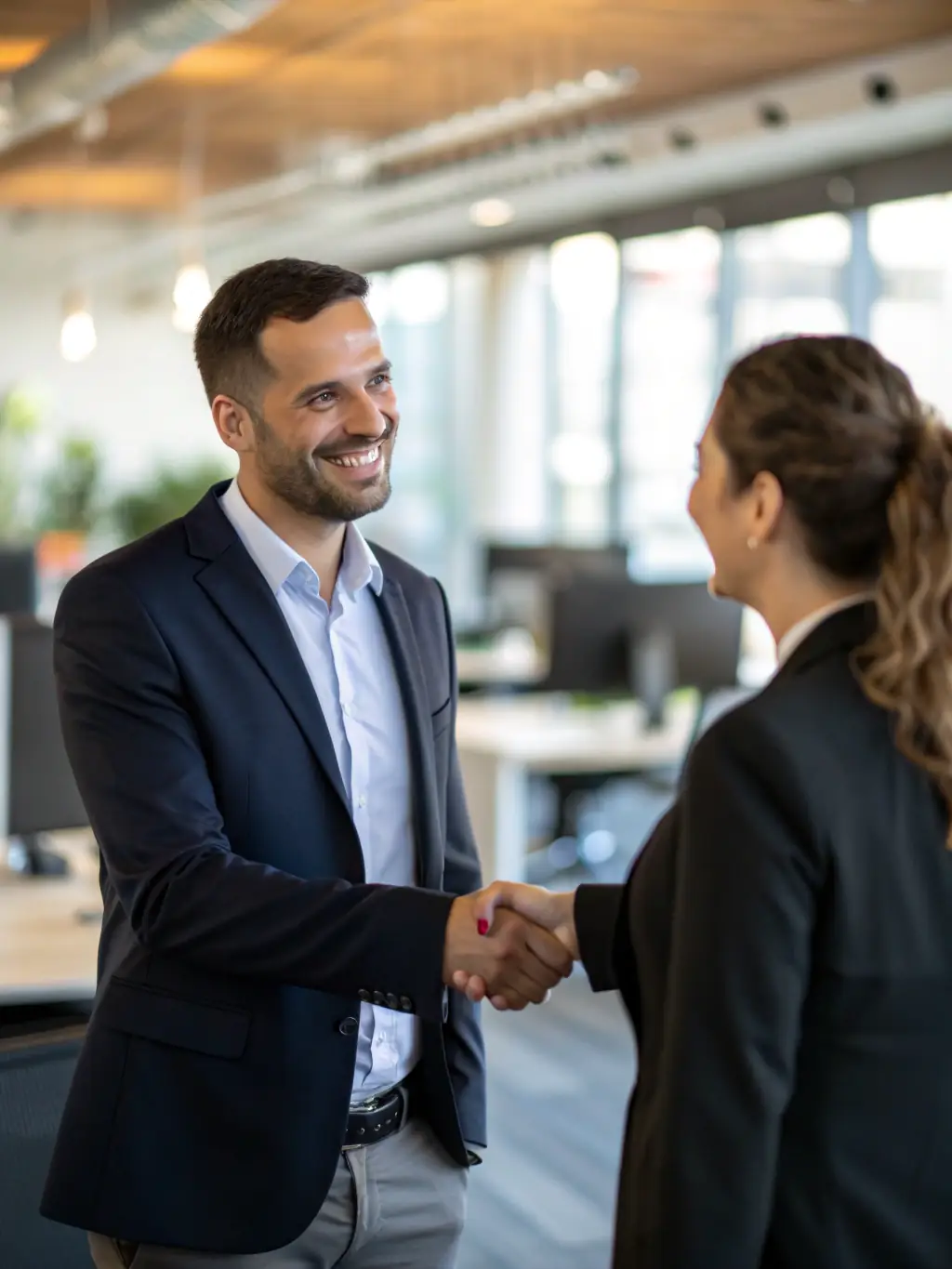 A handshake between a consultant and a client in a modern office, symbolizing trust, partnership, and successful collaboration, with emerald green accents in the background.